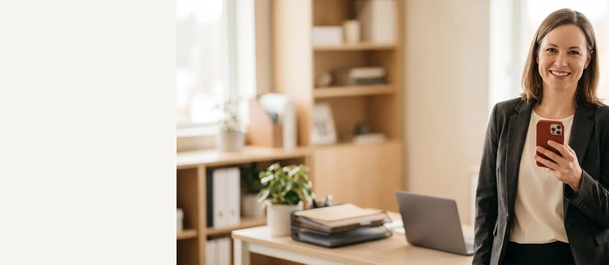 Accountant standing in a bright office with a phone in hand